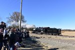 The proud group of photographers in the photo line video and photograph the 0-6-0 9 steam locomotive making a reverse move on the main track toward the freight cars. 